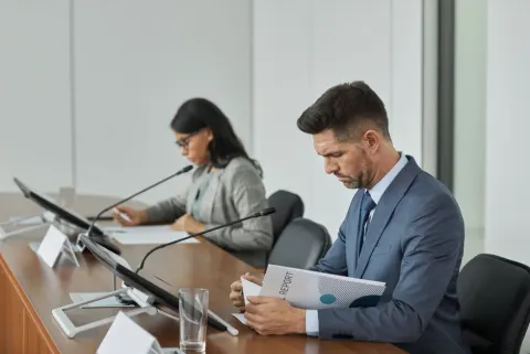 Professionnels réunis autour de documents dans une salle de conférence