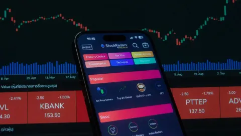 Smartphone affichant une application de bourse devant des graphiques de marché